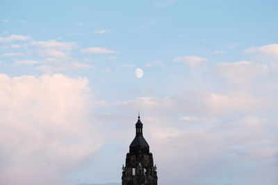 Tower of building against cloudy sky