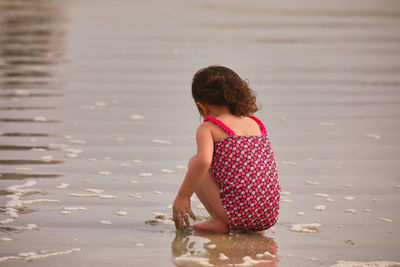 Rear view of woman standing in water