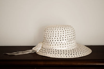 Close-up of hat on table against wall