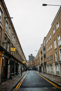 Street amidst buildings against sky in city