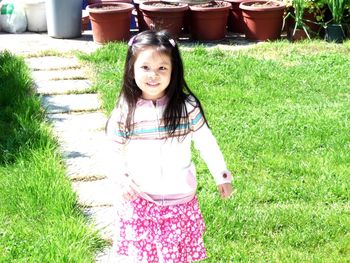 Portrait of happy girl standing in lawn