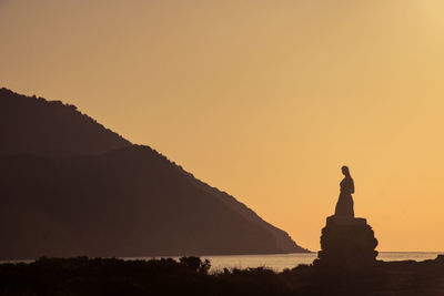 Silhouette of statue at sunset