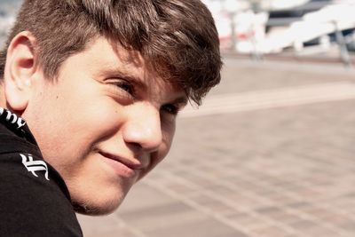 Close-up of thoughtful boy smiling outdoors