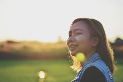 Portrait of smiling young woman against sky