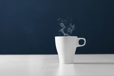 Close-up of coffee cup on table against black background