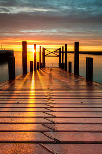 Pier over sea against sky during sunset