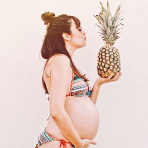 Midsection of young woman standing against white background