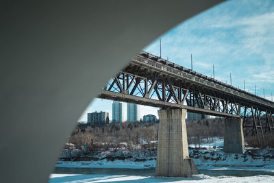 Bridge over river against sky during winter