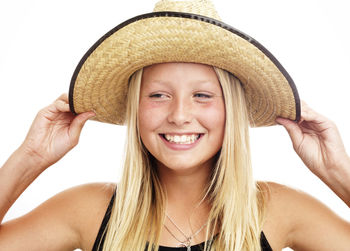 Portrait of smiling girl wearing straw hat, studio shot