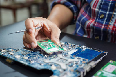 Midsection of person working on computer equipment