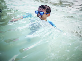 Smiling boy swimming in pool