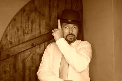 Portrait of man wearing hat against wall