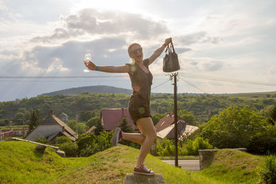 Full length of dancing woman on hill