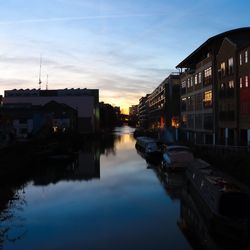 Reflection of houses in water against sky