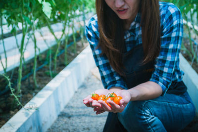 Midsection of woman holding fruit