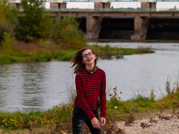 Teenage girl tossing hair while standing river