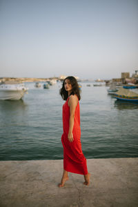 Woman standing in sea against sky