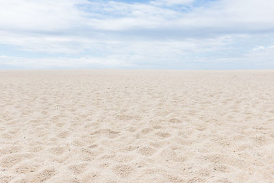 Scenic view of sand dunes against sky