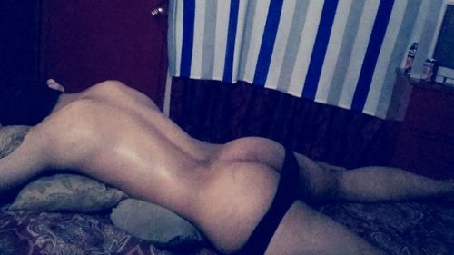 Low section of woman lying on bed at home