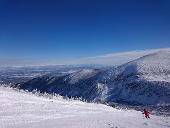 Scenic view of snowcapped mountains against clear blue sky