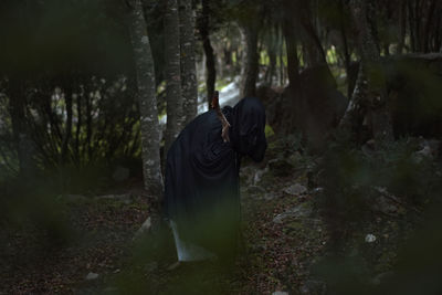 Person with covered face in forest