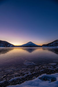 Scenic view of snowcapped mountains against clear sky during winter