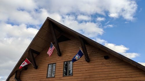 Low angle view of flag on house against sky