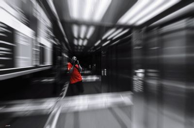 Blurred motion of man walking on railroad station