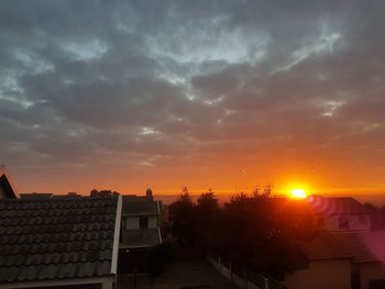 Houses against sky at sunset