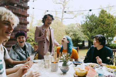 Happy friends of lgbtq community having fun with each other during dinner party in back yard