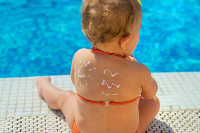 High angle view of shirtless boy swimming in pool