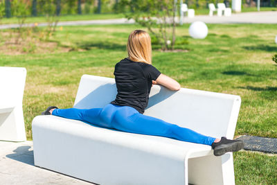 Rear view of woman sitting on grass