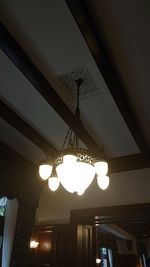 Low angle view of illuminated pendant lights hanging from ceiling in building