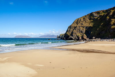 Scenic view of beach against blue sky