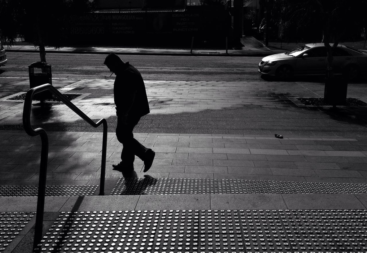 lifestyles, full length, leisure activity, men, shadow, sunlight, walking, street, transportation, rear view, outdoors, person, standing, sidewalk, city life, railing, mode of transport