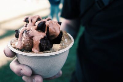 Close-up of hand holding ice cream in bowl