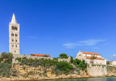 Buildings in city against clear blue sky