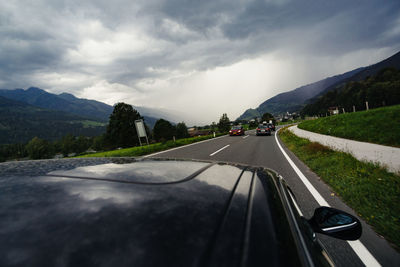 Car on road against cloudy sky