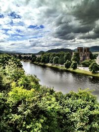 Scenic view of river against cloudy sky