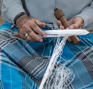 Close-up of hands weaving net