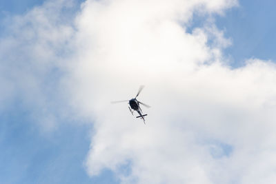 A helicopter flying against blue sky.