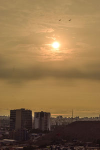 Silhouette buildings against sky during sunset