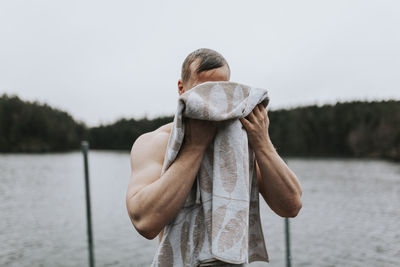 Man at lake drying himself with towel