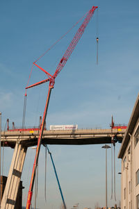 Low angle view of cranes against sky