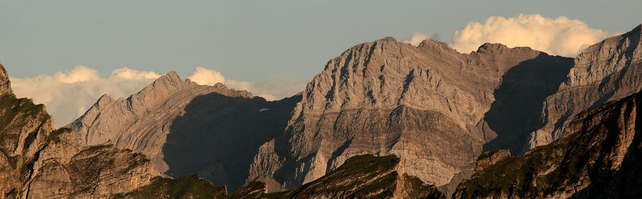 Panoramic view of rocky mountains against sky during sunset