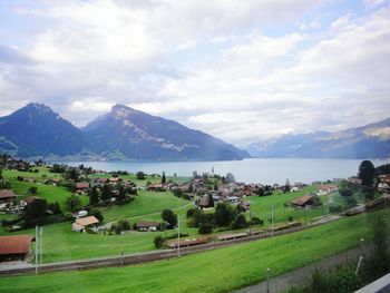 Scenic view of green landscape and mountains against sky