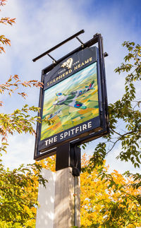 Low angle view of sign board against sky