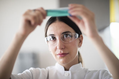 Scientist female with lab glasses, tablet and sample in a lab