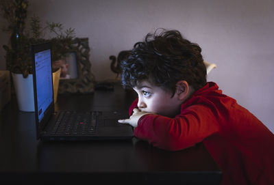 Portrait of boy using mobile phone at table