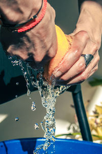 Close-up of man holding hands in water